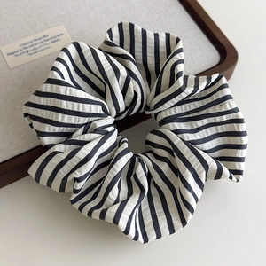 Detailed close-up of a black and white striped fabric scrunchie with seersucker texture