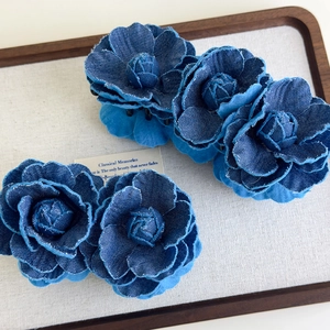 Detail view of denim camellia hair clips in a set with double and triple flower layers