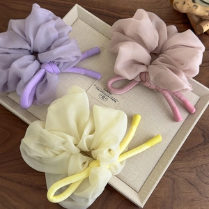 Three oversized chiffon scrunchies in purple, pink, and beige with long ribbon ties
