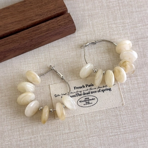 Detail of French vintage hoop earrings featuring marbled acrylic beads on silver metal rings