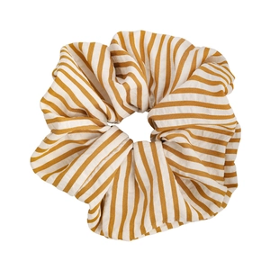Detailed view of yellow and cream striped fabric scrunchie with soft cotton texture