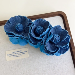 Detailed view of handmade denim camellia flowers on a vintage style hair claw clip