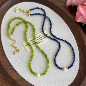 Lapis lazuli and freshwater pearl necklace with golden clasp on an elegant tray