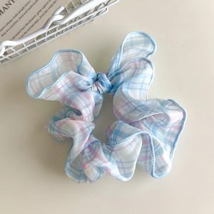 Λεπτομέρεια από καρό scrunchie σε ροζ και μπλε χρώμα με μαλακές πτυχές υφάσματος