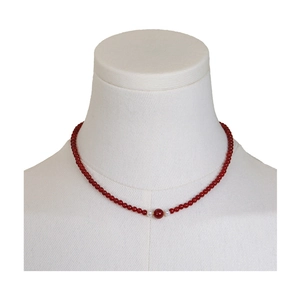 Vintage red agate beaded necklace with elegant white pearls and a gold spacer on a display stand