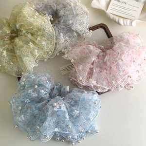 Detailset van vier bloemen kanten scrunchies met parels in zachte pastelkleuren