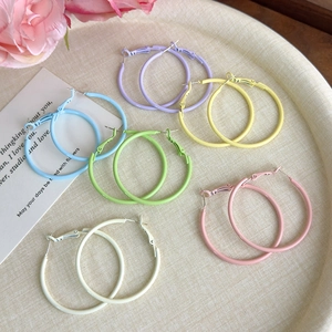 Set of six colorful matte hoop earrings in macaron tones on a stylish woven tray