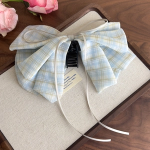 Detailed view of the blue plaid bow hair claw with elegant grey ribbon accents