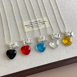 Close-up of colorful resin heart pendant necklaces with silver beaded chains
