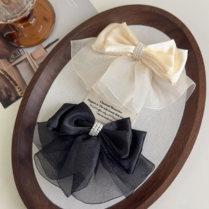 Elegant satin and organza bow hair clips with pearls shown in cream and black colors