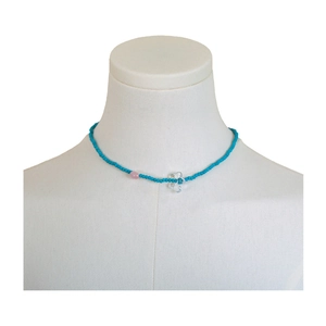 Collana di perline azzurre con perla rosa e ciondolo a fiore trasparente su busto esposizione