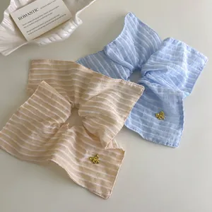 Chouchous rayés bleu et beige avec breloques dorées sur une table blanche pure