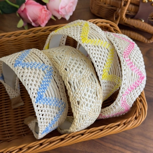 Detail view of woven bohemian headbands in light blue, white, yellow and pink colors
