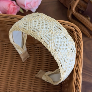 Close-up of beige bohemian braided wide headband featuring intricate raffia weave patterns