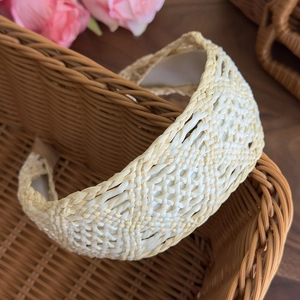Detail of bohemian cream woven headband with straw texture and wide comfort design