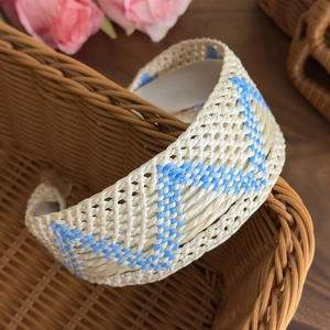 Detail view of Bohemian woven headband with blue zigzag patterns in a basket