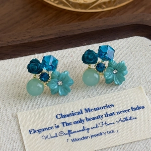 French vintage blue crystal flower stud earrings on a rustic canvas and wooden tray