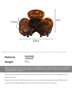 Detail view of acetate tortoise shell hair claw clip with black rose floral accent