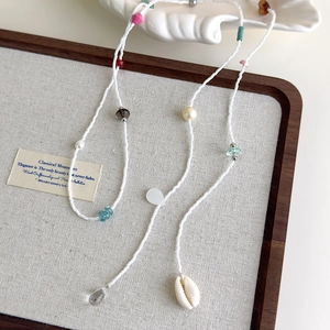 Détail du collier de perles colorées avec pendentif coquillage et perles pour l'été