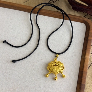 Détail d'un pendentif serrure de longévité doré traditionnel avec caractère Fu et grelots