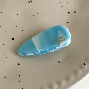 Détail d'une barrette en acétate marbré bleu avec inscription dorée Barrette la France