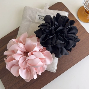 Élastiques à cheveux fleurs en satin rose et noir sur un élégant plateau en bois