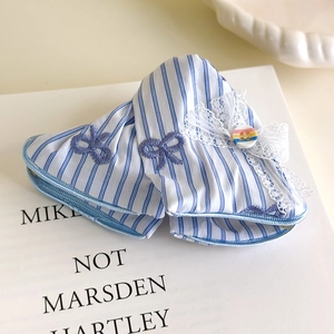 Détail de pince à cheveux en tissu rayé bleu avec nœud en dentelle et bouton coloré