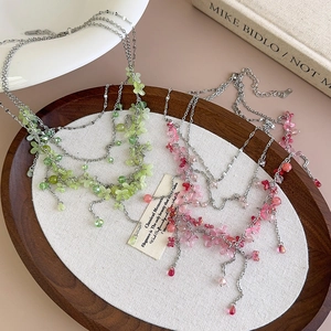 Pink and green layered beaded flower necklaces with vintage floral petals on wood tray