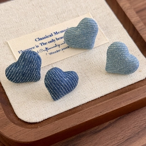 Retro denim blue heart-shaped button earrings with polka dot texture on linen tray