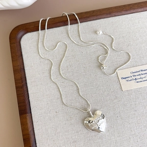 Detail of heart pendant with Forever My Love engraving and textured silver finish