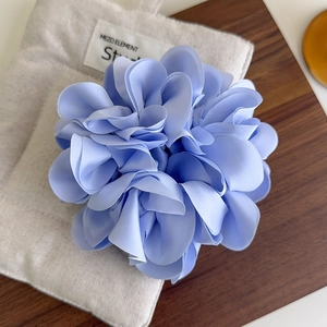 Détail d'un chouchou fleur en mousseline bleu clair sur un fond rustique élégant