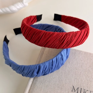 Close-up of red and blue pleated fabric headbands showing handcrafted texture and details