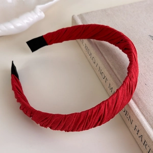Detail of dark red pleated fabric headband with fine texture and black comfort tips