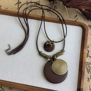 Détail du collier ethnique vintage avec pendentif spirale en bronze et perle en bois