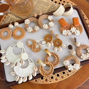 Detail von böhmischen gewebten Ohrringen mit Rattan-Texturen, Muscheln und Blumen