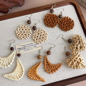 Handmade bohemian woven earrings set with wooden beads and natural fiber charms