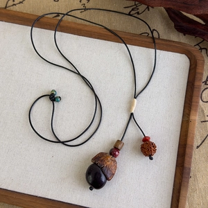 Détail d'un collier ethnique fait main avec graines naturelles et perles de bodhi