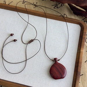 Détail du pendentif en séquoia fait main sur cordon tressé marron réglable pour colliers