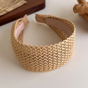 Gros plan d'un serre-tête en paille tressée naturelle avec une texture détaillée