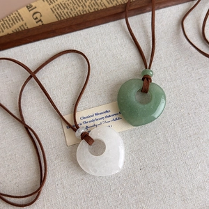 Detail of natural heart-shaped stone pendants in light green and milky white colors