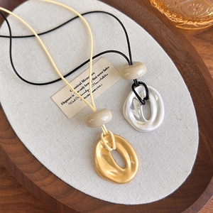 Detailed close-up of minimalist irregular oval pendants on adjustable cord necklaces