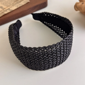 Détail d'un serre-tête large noir tressé avec texture en maille de fibres synthétiques