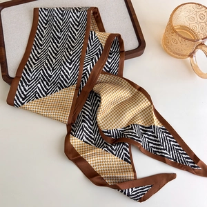 Detail of multi-functional silk scarf featuring yellow houndstooth and geometric patterns
