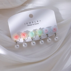 Six paires de boucles d'oreilles roses et perles aux tons pastels sur soie blanche