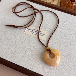 Close-up of a heart-shaped yellow quartz pendant on a retro long cord necklace