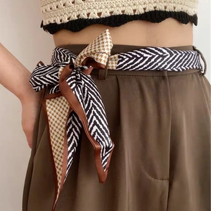 Chic houndstooth long silk scarf worn as a fashion waist belt on trousers