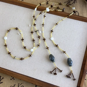 Détail d'un collier artisanal en perles de style ethnique avec pendentifs en céramique