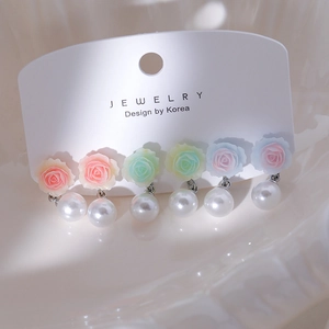 Détail de boucles d'oreilles camélia et perles en résine pastel rose verte et bleue design