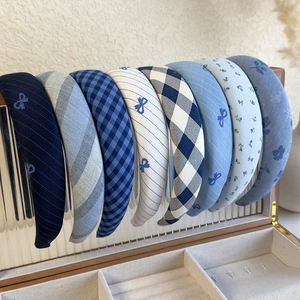 Set of eight blue plaid and floral sponge headbands displayed in a jewelry storage box