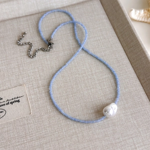 Detailaufnahme der blauen Perlenkette mit großer Barockperle und Seestern-Dekoration